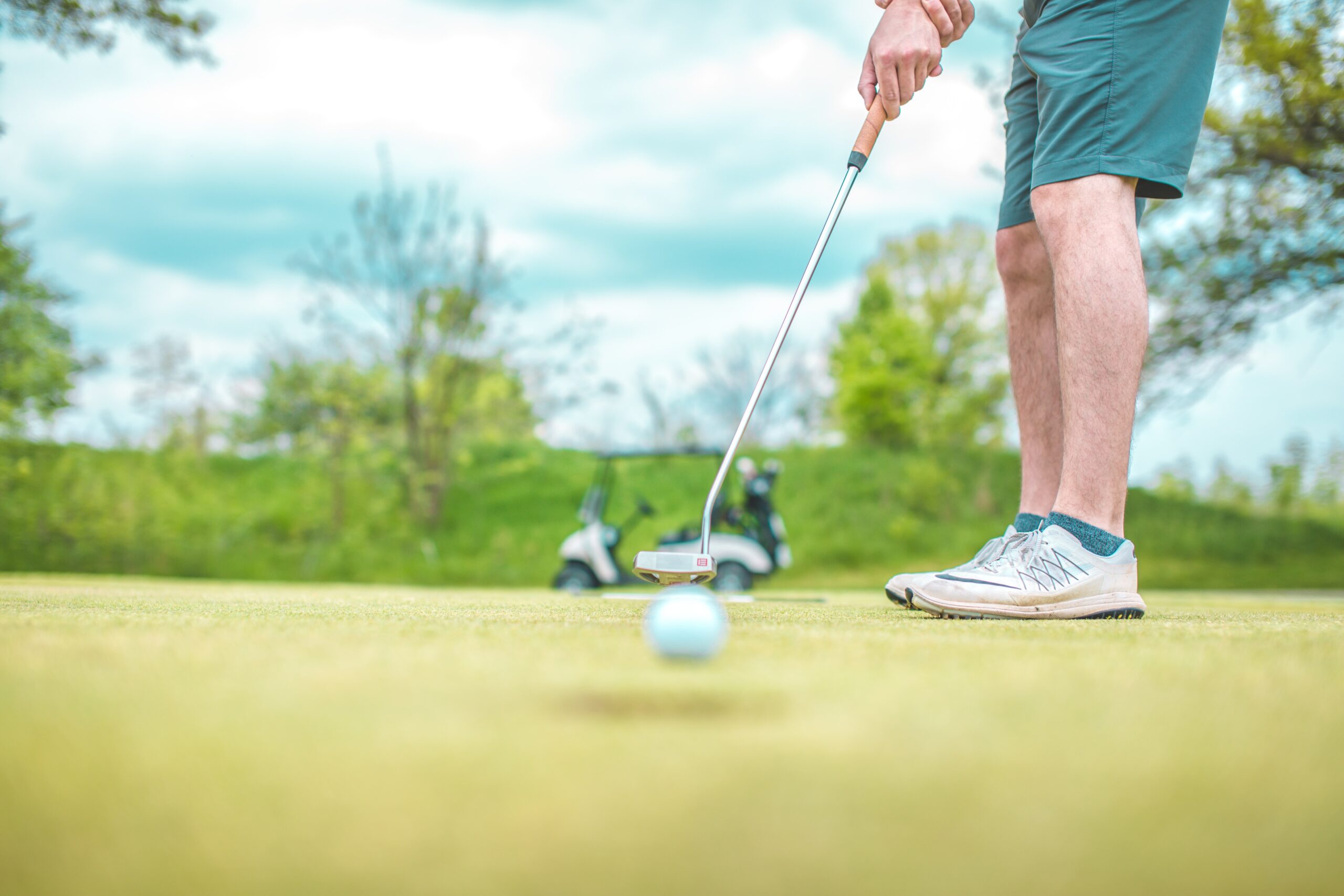 Golfer putting the ball into the hole on vacation