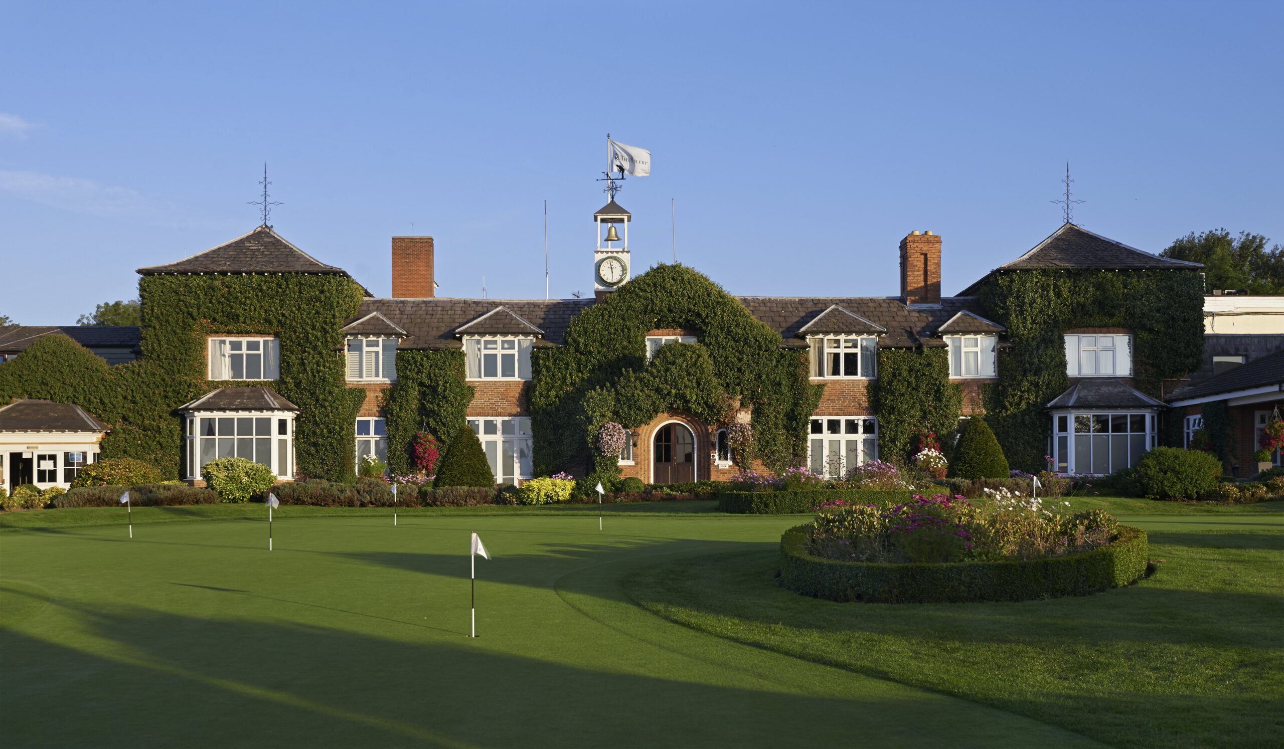 The practice putting green and Belfry Hotel