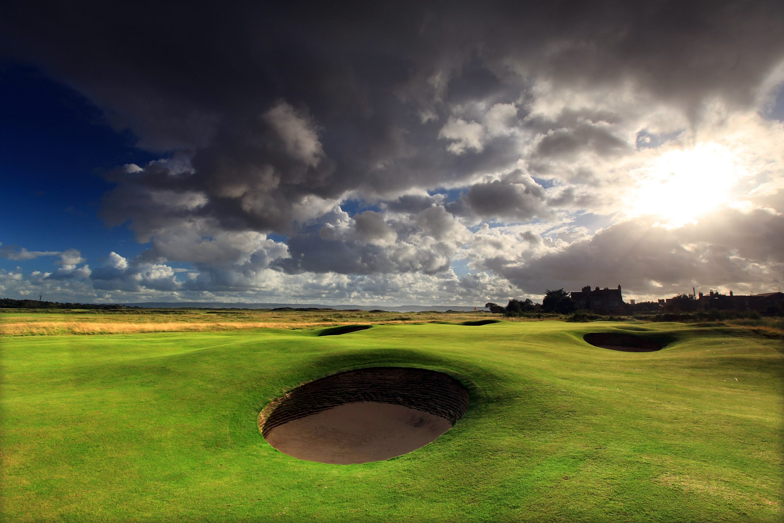 Dramatic low sunlight cutting through the dark clouds over Royal Liverpool Golf Club