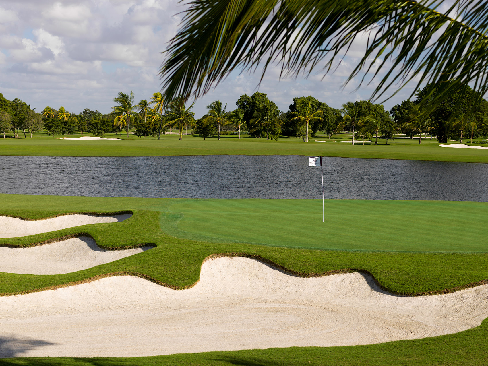 A green protected by a bunker and a lake at Trump National Doral Miami