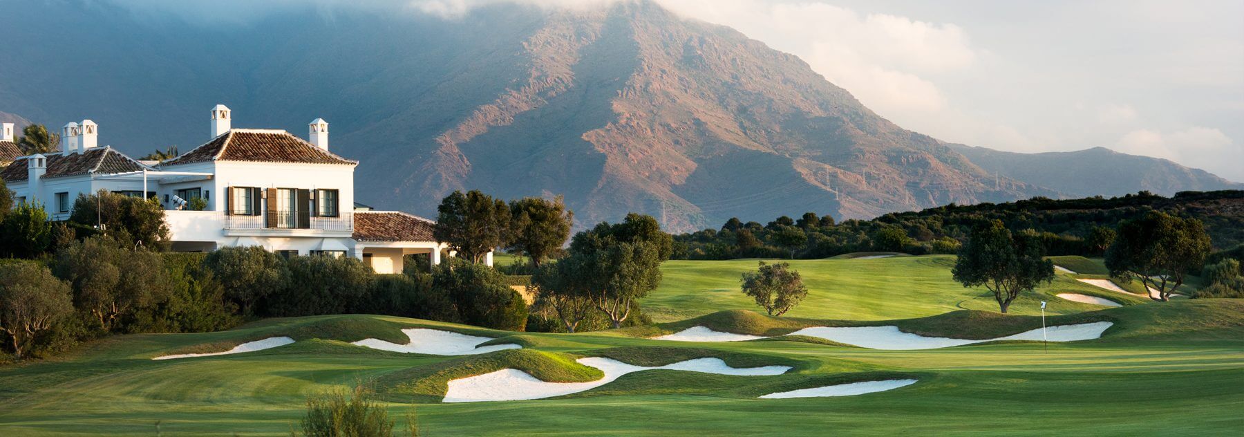 Finca Cortesin fairways and clubhouse with misty mountains in Spain