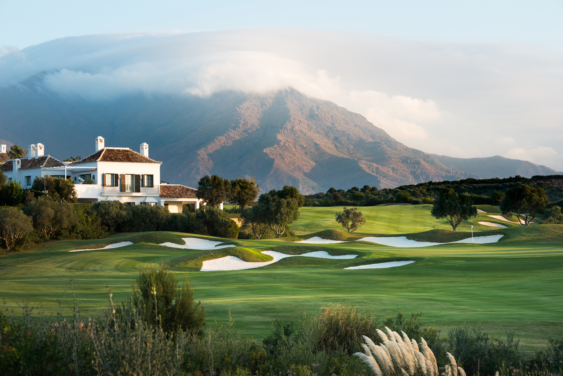 Finca Cortesin fairways and clubhouse with misty mountains in Spain