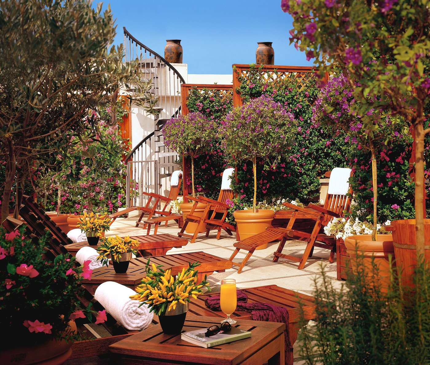 Floral terrace with wooden tables and chairs at Hotel Dei Melini in Rome,